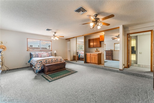 carpeted bedroom with baseboards, a ceiling fan, a textured ceiling, and visible vents