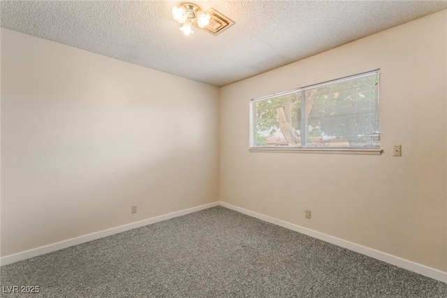 carpeted empty room with baseboards, a textured ceiling, and visible vents