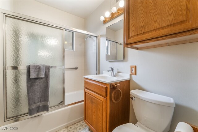 full bath featuring vanity, toilet, and shower / bath combination with glass door