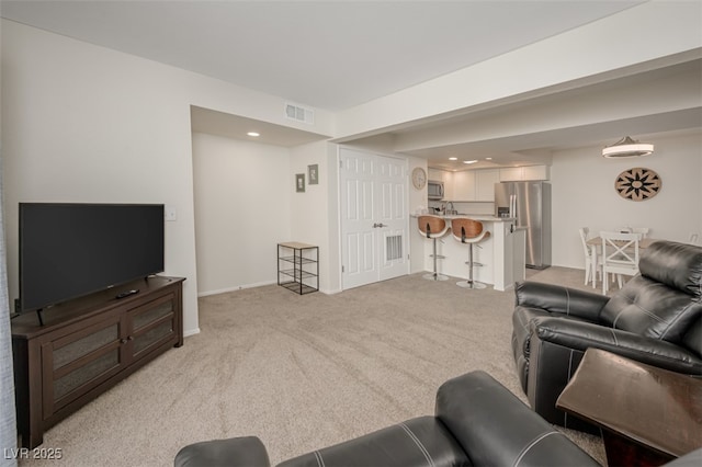 living room with baseboards, light carpet, recessed lighting, and visible vents