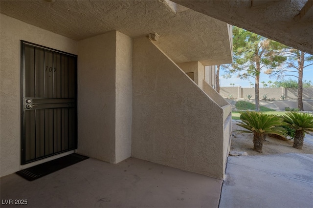 doorway to property featuring a patio area and stucco siding