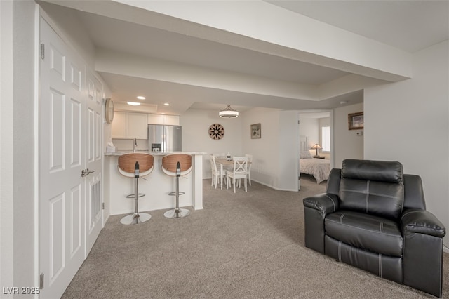 carpeted living area with a sink and recessed lighting
