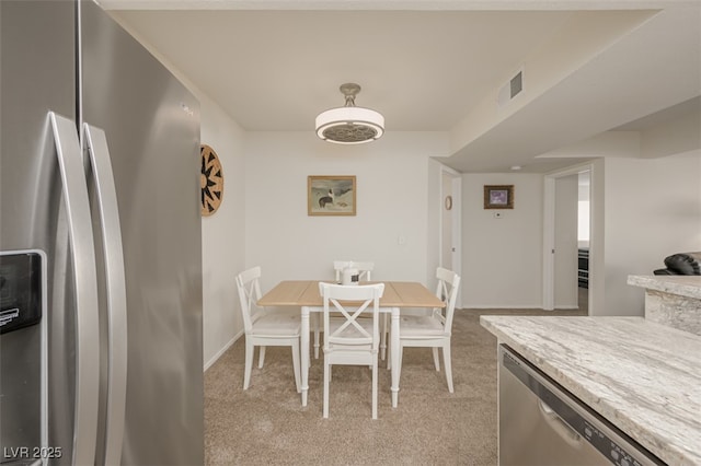 dining room with baseboards, light carpet, and visible vents