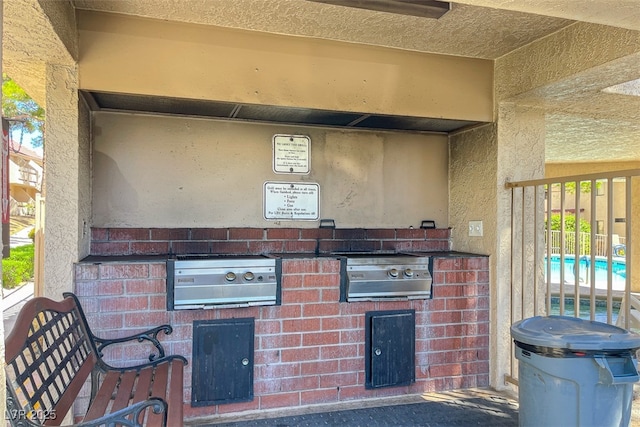 view of patio / terrace featuring an outdoor kitchen, fence, and a grill