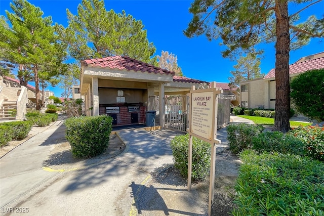 view of front of property featuring a gate, stucco siding, a tile roof, and fence