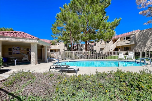 community pool featuring a patio and fence