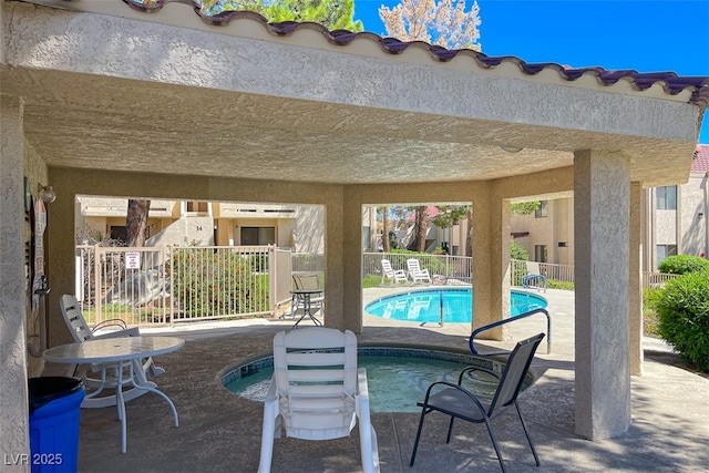 view of patio / terrace with a community pool, fence, and a community hot tub