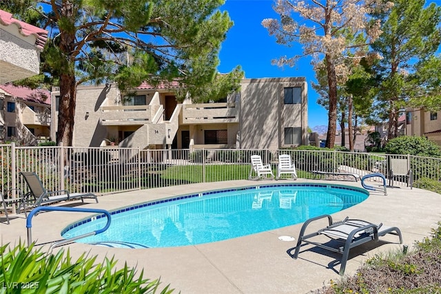 community pool with a patio and fence