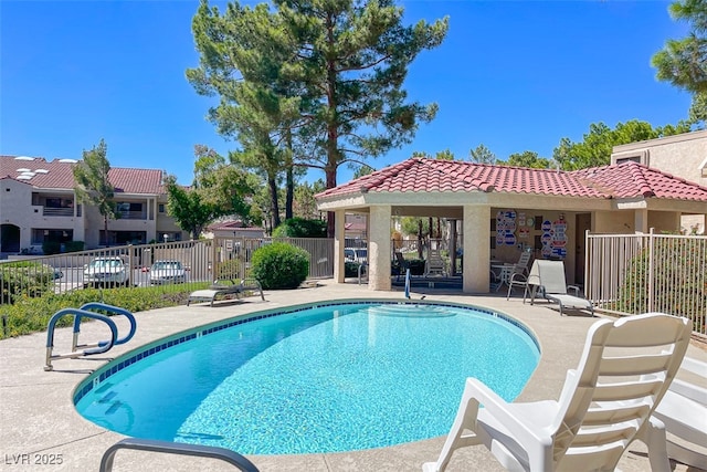 pool with fence and a patio