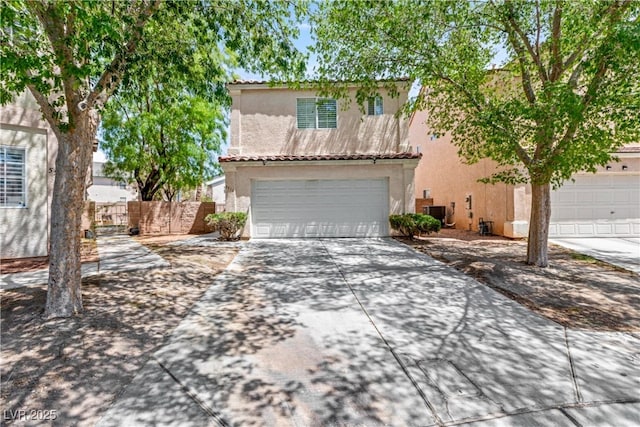 traditional-style home featuring driveway, a garage, fence, cooling unit, and stucco siding