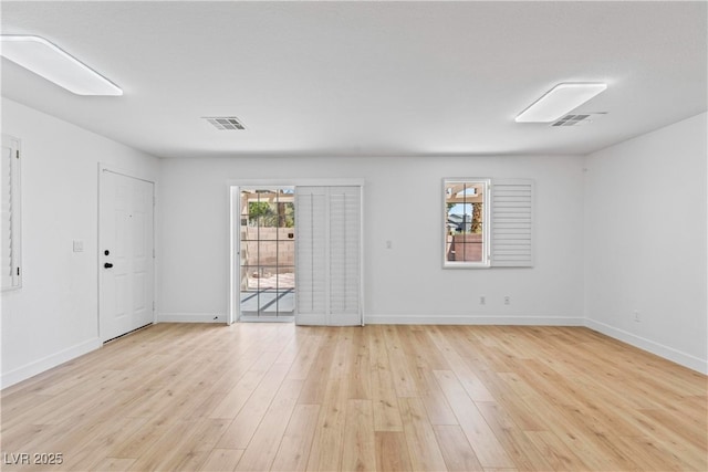 unfurnished room featuring light wood-style floors, baseboards, and visible vents
