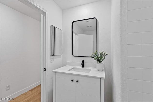 bathroom featuring vanity, baseboards, and wood finished floors