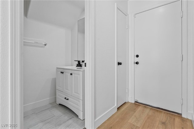 bathroom with vanity, baseboards, and wood finished floors