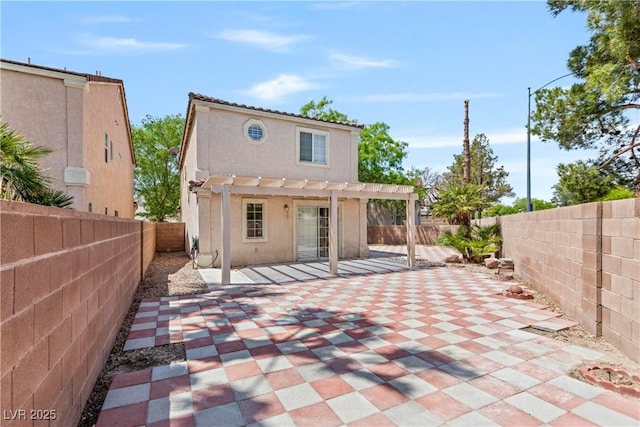 rear view of house featuring a fenced backyard, a patio area, stucco siding, and a pergola