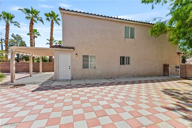 back of house featuring fence, a pergola, stucco siding, and a patio area