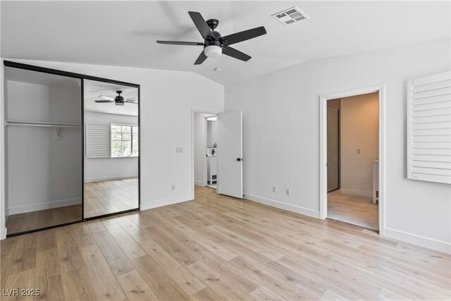 unfurnished bedroom featuring ceiling fan, visible vents, baseboards, light wood finished floors, and lofted ceiling