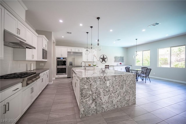 12018 Vento Forte Ave, Las Vegas, NV 89138 - kitchen featuring built in appliances, recessed lighting, a large island, baseboards, and white cabinets