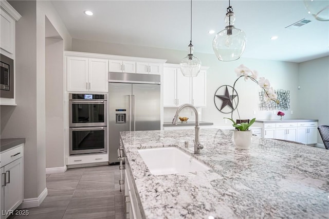 12018 Vento Forte Ave, Las Vegas, NV 89138 - kitchen with built in appliances, a sink, light stone countertops, recessed lighting, and decorative light fixtures
