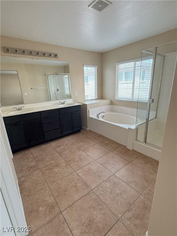 full bathroom with double vanity, visible vents, a shower stall, a sink, and tile patterned floors