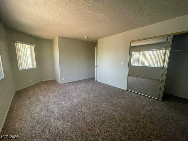 unfurnished bedroom featuring a textured ceiling, carpet, and a closet