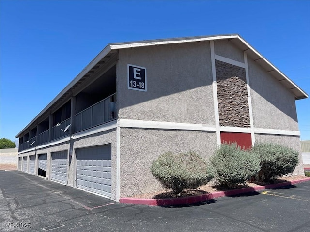 view of property featuring an attached garage and aphalt driveway