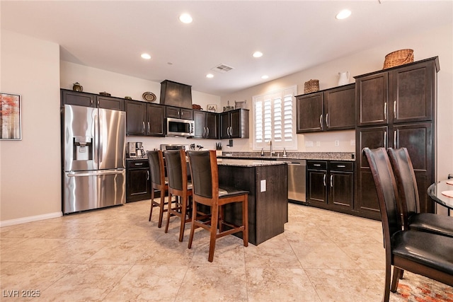 63 Via Di Mello, Henderson, NV 89011 - kitchen with stainless steel appliances, a kitchen bar, a kitchen island, a sink, and recessed lighting