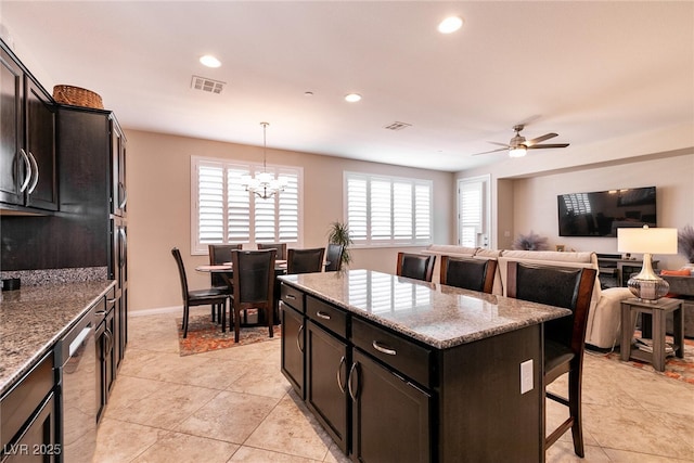 63 Via Di Mello, Henderson, NV 89011 - kitchen with a kitchen bar, dishwasher, light stone counters, recessed lighting, and a kitchen island