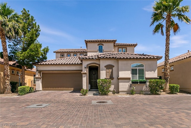63 Via Di Mello, Henderson, NV 89011 - mediterranean / spanish-style home with stucco siding, an attached garage, decorative driveway, and a tile roof