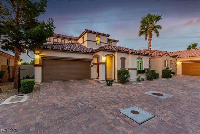 63 Via Di Mello, Henderson, NV 89011 - mediterranean / spanish home featuring stucco siding, an attached garage, a tile roof, and driveway