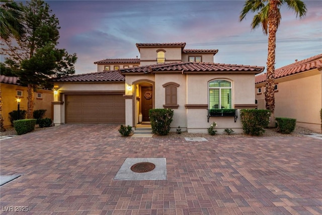 63 Via Di Mello, Henderson, NV 89011 - mediterranean / spanish-style home featuring stucco siding, an attached garage, decorative driveway, and a tiled roof