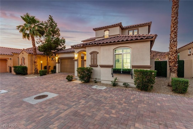 63 Via Di Mello, Henderson, NV 89011 - mediterranean / spanish house featuring stucco siding, a garage, decorative driveway, and a tiled roof