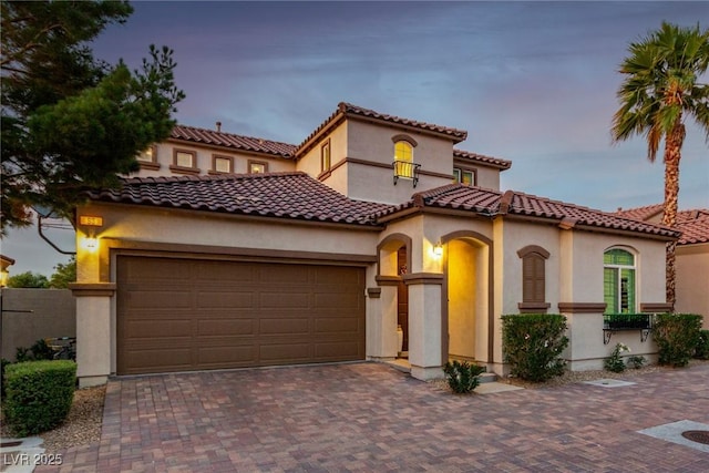 63 Via Di Mello, Henderson, NV 89011 - mediterranean / spanish house featuring an attached garage, stucco siding, and driveway
