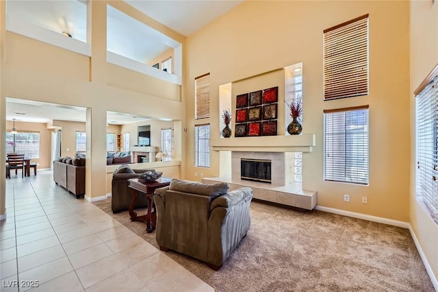 4 Bishopsgate Ter, Henderson, NV 89074 - carpeted living area with a fireplace, a towering ceiling, baseboards, and tile patterned floors