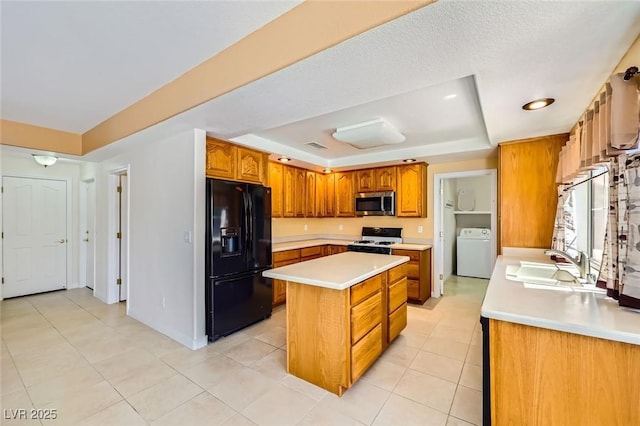4 Bishopsgate Ter, Henderson, NV 89074 - kitchen with black refrigerator with ice dispenser, washer / clothes dryer, white range with gas cooktop, stainless steel microwave, and a tray ceiling