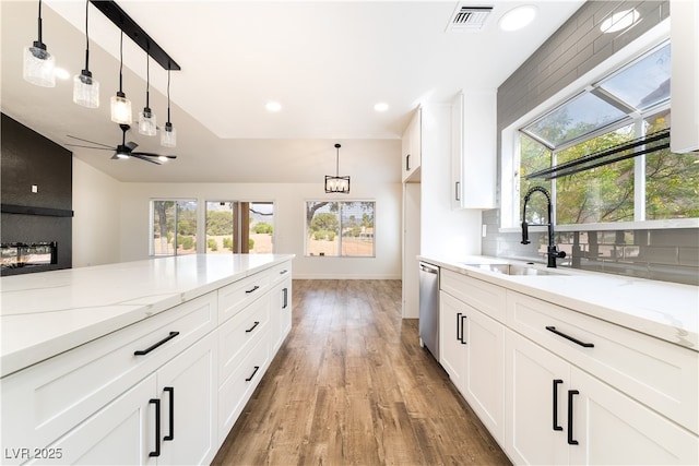 2505 Showcase Dr, Las Vegas, NV 89134 - kitchen with a sink, stainless steel dishwasher, light wood finished floors, a ceiling fan, and decorative light fixtures