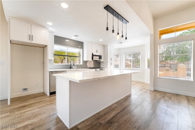 2505 Showcase Dr, Las Vegas, NV 89134 - kitchen featuring appliances with stainless steel finishes, white cabinetry, tasteful backsplash, recessed lighting, and a kitchen island