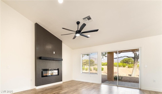 2505 Showcase Dr, Las Vegas, NV 89134 - unfurnished living room with vaulted ceiling, a large fireplace, wood finished floors, ceiling fan, and baseboards