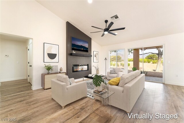 2505 Showcase Dr, Las Vegas, NV 89134 - living room featuring light wood-style floors, ceiling fan, a fireplace, and high vaulted ceiling