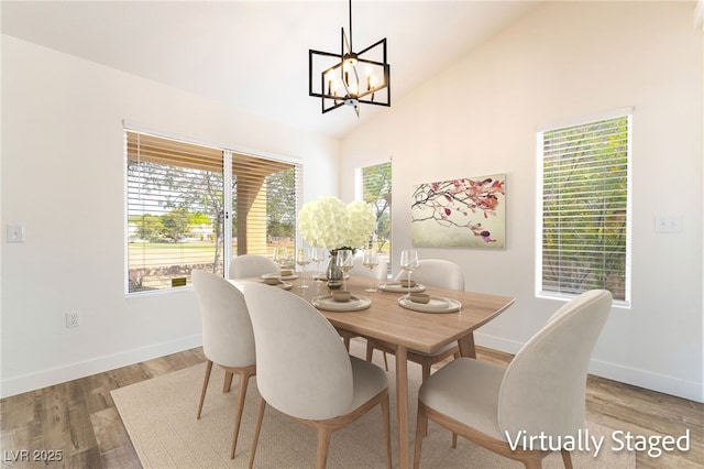 2505 Showcase Dr, Las Vegas, NV 89134 - dining room with baseboards, a chandelier, wood finished floors, and high vaulted ceiling