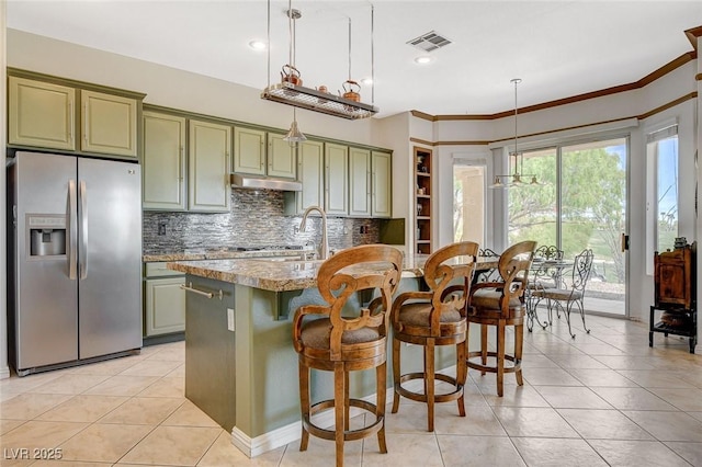 kitchen featuring backsplash, stainless steel refrigerator with ice dispenser, visible vents, light tile patterned floors, and green cabinets
