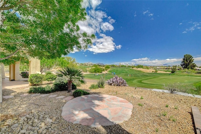 view of yard featuring view of golf course and a patio area