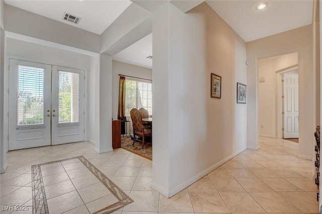 entrance foyer with light tile patterned flooring, baseboards, visible vents, and french doors