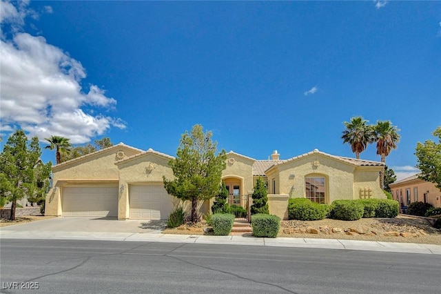 mediterranean / spanish home featuring a garage, stucco siding, concrete driveway, and a tile roof