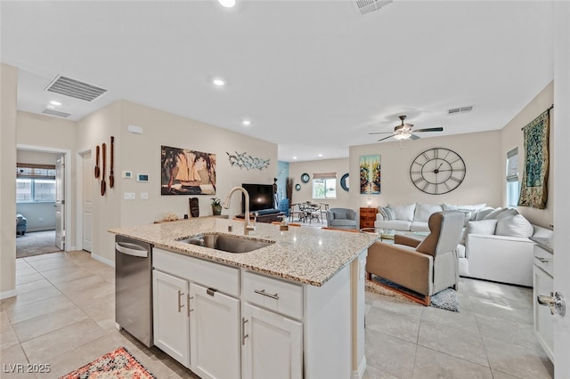 kitchen featuring visible vents, a center island with sink, dishwasher, a sink, and light tile patterned floors