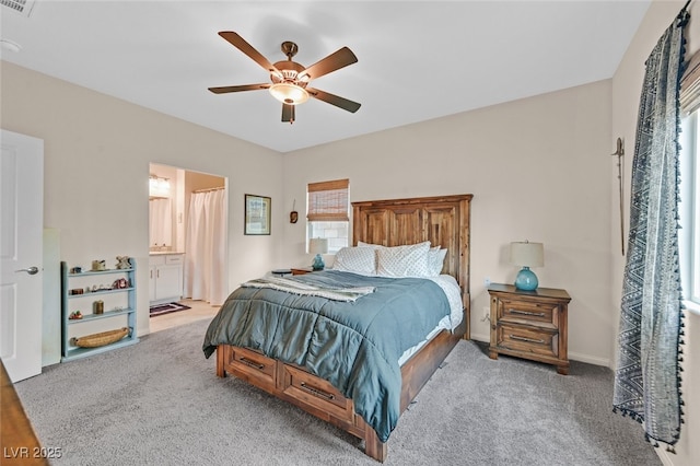 bedroom featuring carpet, a ceiling fan, and ensuite bath