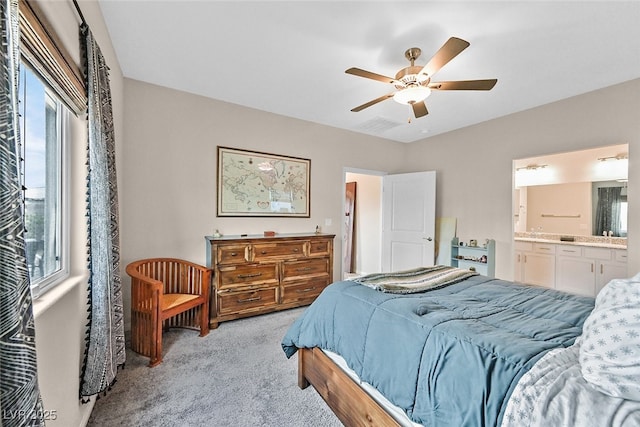 bedroom with connected bathroom, ceiling fan, and light colored carpet