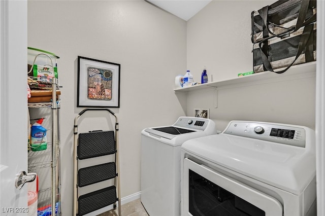 laundry area featuring separate washer and dryer, laundry area, light tile patterned floors, and baseboards