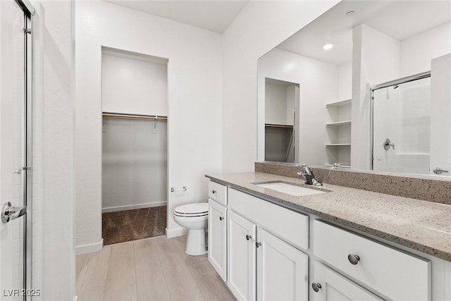 2733 Avril Point St, Las Vegas, NV 89156 - full bathroom with toilet, a shower with door, a walk in closet, and wood finished floors