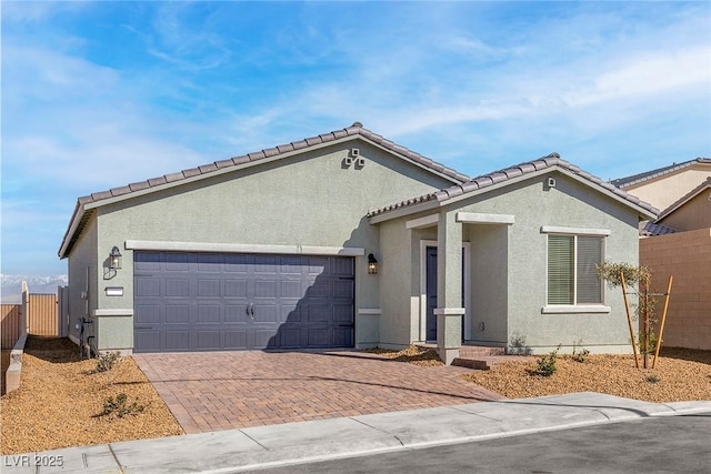 2733 Avril Point St, Las Vegas, NV 89156 - ranch-style house with fence, a garage, stucco siding, decorative driveway, and a tiled roof