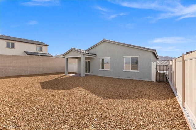 2733 Avril Point St, Las Vegas, NV 89156 - rear view of property with a tile roof, a gate, a fenced backyard, and stucco siding